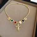 Detailed macro view of a vintage golden cross necklace with colorful gemstones on velvet - 74# Necklace-Gold-Multicolor (Cross Vintage)