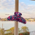 Pink and blue marbled acetate hair claw clip shown against a scenic lake background - Radiant Purple