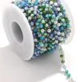 Close-up of mixed color faceted crystal bead chain on gold spool for DIY jewelry - Gold-Green Multi