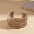 Detail view of wide C-shaped resin bangle with brown marble texture on beige background - Light Coffee (Marble Pattern)