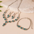 Detailed view of luxury peacock blue crystal jewelry set on white natural stone - 3-Piece Blue Stud Earrings Bracelet Necklace Set