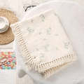 Detail of soft cream gauze baby blanket featuring small floral prints and elegant tassel trim - Orchid