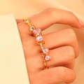 Golden multi-heart ring featuring pink heart-shaped stones and a delicate bow detail - Gold-Tone Pink Heart Ring (11259) / Pink