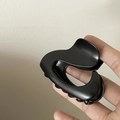 Detalle de una pinza para el pelo grande en negro mate con un diseño curvo elegante - Corazón Hueco/Irregular / Negro mate