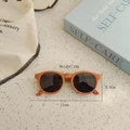 Top view of orange silicone toddler sunglasses with dimensions and lifestyle props - Orange