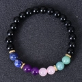Macro shot of natural stone bracelet with black beads and colorful chakra accents - Black Onyx Mixed with Rainbow Colored Beads (Style-7)
