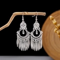 Detail view of silver bohemian long leaf tassel earrings hanging on a natural branch - Silver Carved Disc Pointed Leaf Tassel Style (E2873-33)