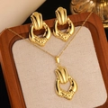 Detailed view of gold geometric necklace and earrings set on a textured display pad - Gold Irregular Pleated Hammered Texture Set