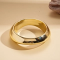 Primer plano de un brazalete ancho de oro pulido con acabado de espejo brillante - Óvalo Dorado
