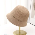Beige crochet knit bucket hat with metal emblem on display stand for women - Khaki / M (56-58cm)