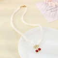 Collana con ciliegia rossa con perle bianche e dettagli dorati su un piatto decorativo bianco - Stile Ciliegia Rossa in Lega Raffinata (KN292063-Z)