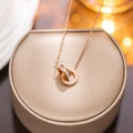 Rose gold Roman necklace with dual rings and zircon pendant on jewelry box - Rose Gold