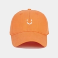 Detail shot of orange baseball cap featuring white smiley face embroidery on cotton twill - Adjustable / Orange
