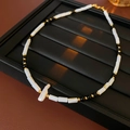 Detalle del collar de nácar estilo bambú con perla barroca y detalles en color dorado - Collar-Blanco y Negro