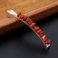Close-up of a silver metal hair clip featuring inlaid irregular natural red crystal stones - Red Jasper with Silver Clip
