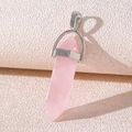 Close-up of hexagonal pink crystal column pendant with silver metal bail on beige paper - Rose Quartz