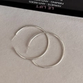 Macro di grandi orecchini a cerchio in argento sterling s925 su una superficie grigia - Perno in Argento - Grande - 5cm