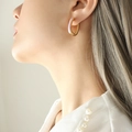 Elegante U-vormige gouden oorbellen met paars emaille gedragen door een model in stijl - Goud Roze