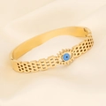 Gold evil eye bangle with hollow geometric texture on a soft silk background - Hollow Lattice Evil Eye Style (4#)