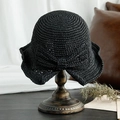 Elegante sombrero de paja negro con lazo grande sobre un soporte de madera retro - M (56-58cm) / Negro