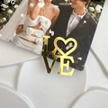 Golden mirror acrylic LOVE cake topper with heart shape O on a white textured background - Heart Letter O Love