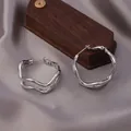 Polished silver twisted hoop earrings with a modern wave design on a silk display - E-061---Platinum