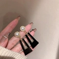 Detail view of long gold drop earrings with white pearls and black geometric pendants - Black Pearl Trapezoid Dangle (9#)