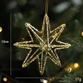 Glittery gold 10cm star Christmas ornament hanging on a festive tree with warm lighting - Gold Small North Star