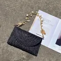 Borsa a busta in paglia nera intrecciata con ciondoli a conchiglia e perle - Nero