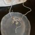 Macro view of butterfly pendant on silver mesh chain with shimmering crystal details - Silver Butterfly Tassel Style