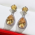 Macro view of pear-cut yellow zircon earrings with silver metal and white pave setting - Yellow Zirconia