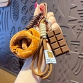 Brown plush pretzel keychain with woven cord and chocolate charm for bags and keys - Plush Food-Pretzel + Chocolate