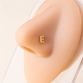 Detail of a gold letter E nose stud with micro-pave cubic zirconia on a model - Letter E / Gold