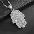 Silberne Hamsa-Hand-Halskette mit funkelnden Strasssteinen auf dunklem Holzgrund - Hamsa Hand Anhänger Nur / Stahlfarbe
