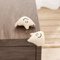 Two cream silicone cartoon animal corner protectors installed on wooden furniture - Fluid-Apricot