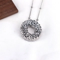 Detail showing silver 3D quilted texture pendant on a fine bead chain necklace - Letter O