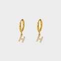 Close-up of gold-plated H-shaped earrings with sparkling pave-set white zirconia stones - Letter H
