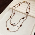 Détail d'un collier à deux rangs en œil de tigre avec perles facettées et accents dorés - Gris