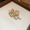 Detaillierte Makroansicht geometrischer Doppelring-Ohrringe mit polierter Goldbeschichtung - Goldene Kettenohrstecker (Silberstift) / Gold