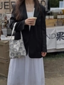 Close-up of cream canvas tote bag with black animal embroidery held by a model - Beige