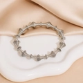 Elegante brazalete de resorte de acero inoxidable plateado sobre tela de seda suave - Color Acero
