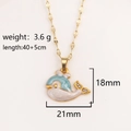 Collana con ciondolo a forma di balena dorata in smalto blu e strass su sfondo beige - Balena Blu (Pesce Palla Blu)