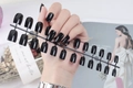 Detail view of glossy black long square press-on nails set displayed on a plastic rack - Black (CFL-01)