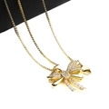 Close-up of golden bow pendant with micro-paved zircons on a delicate box chain - Pendant And Necklace (2)