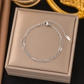 Elegant silver double-layer chain bracelet with adjustable lobster clasp on jewelry box - Curb Chain Silver