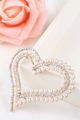 Elegant gold heart brooch with pearls and rhinestones on a white textured surface - Xd825295