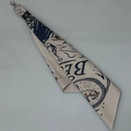 Detailaufnahme des beigen Baumwoll-Bandanas mit Vintage-Muster und Leder-Metallverschluss - Schal-Anhänger / Weiße Dame mit Ring