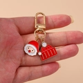 Handheld Christmas keychain with Santa charm, red knitted hat, and golden alloy finish - Santa Claus