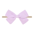 Close-up of a light purple linen bow on a soft nude nylon headband for infants - Light Purple