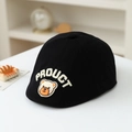 Close-up of black cotton kids flat cap featuring a brown bear patch and white embroidery - 50cm (1-3 Years) / Black